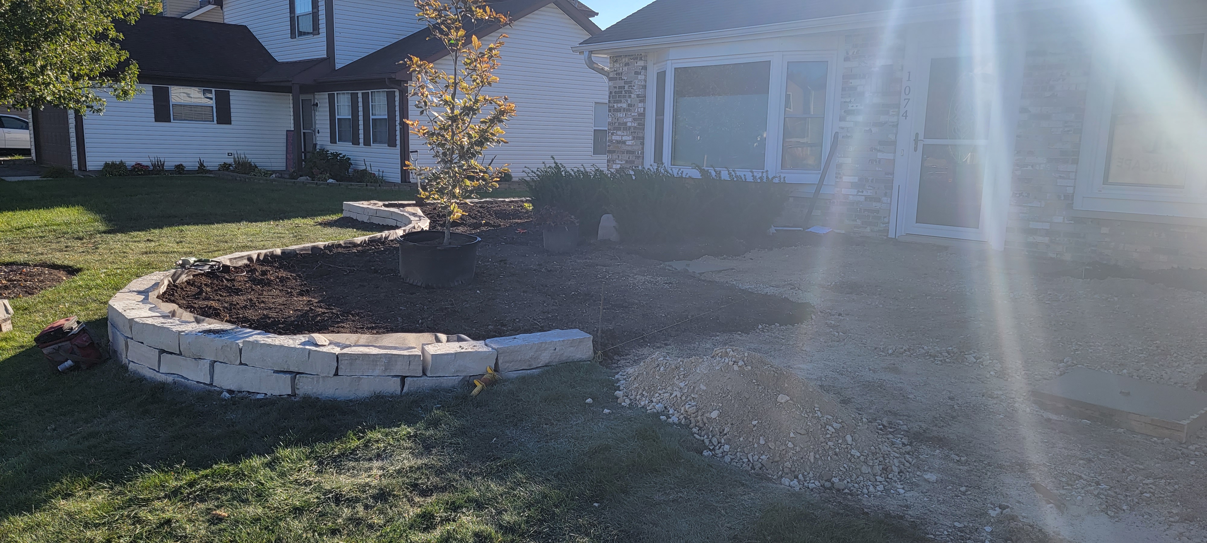 Natural stone retaining wall installation in progress, Carol Stream, IL — B&L Landscape drainage and grading